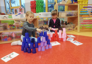 dziewczynki układają wieże z kubeczków